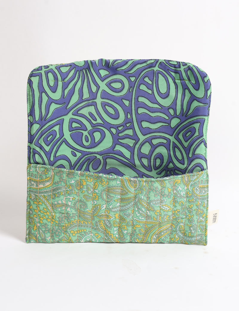 Quilted sunglasses case with green paisley exterior and blue-green abstract patterned interior, flat open view