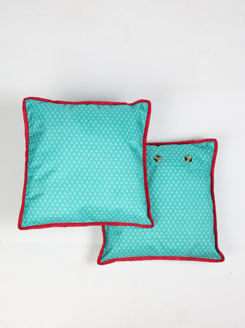 Set of two blue cushion covers with small arrow pattern and red piping edges, one showing two buttons on back side