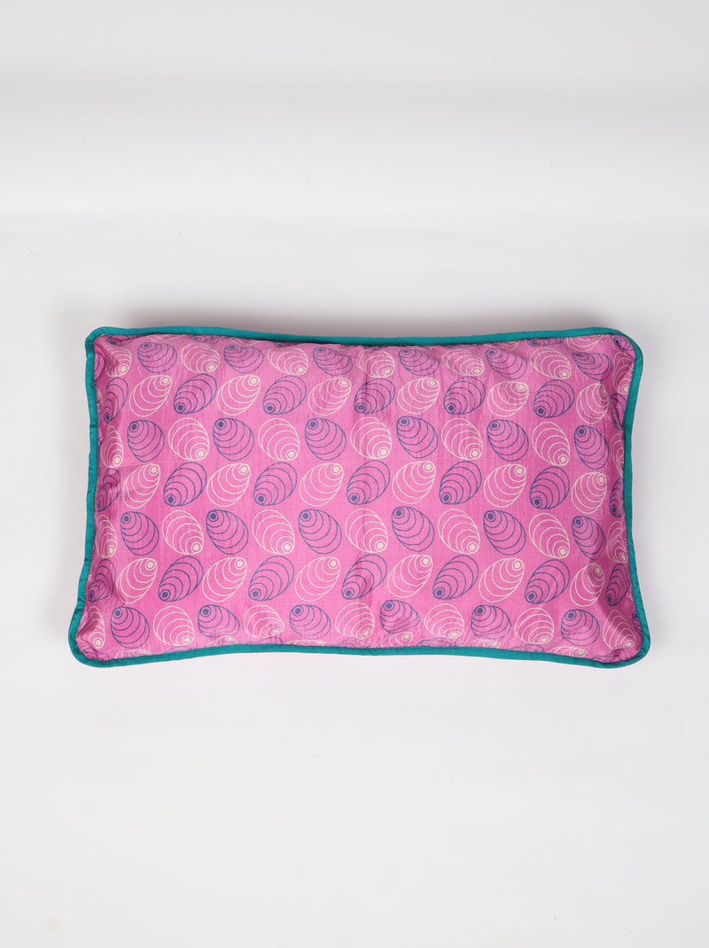 Rectangular pink lumbar cotton cushion cover with blue piping edge and shell pattern, flat lay view on white background