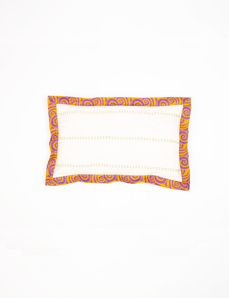 Lumbar cotton cushion cover with white center, yellow stitching, and broad yellow and purple abstract sari edging, flat lay