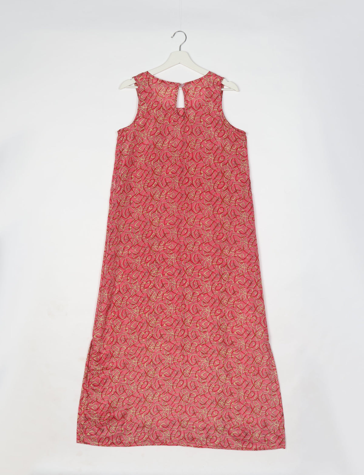 Sleeveless pink A-line dress with beige and red leaf pattern, keyhole back, hanging on white hanger, back view