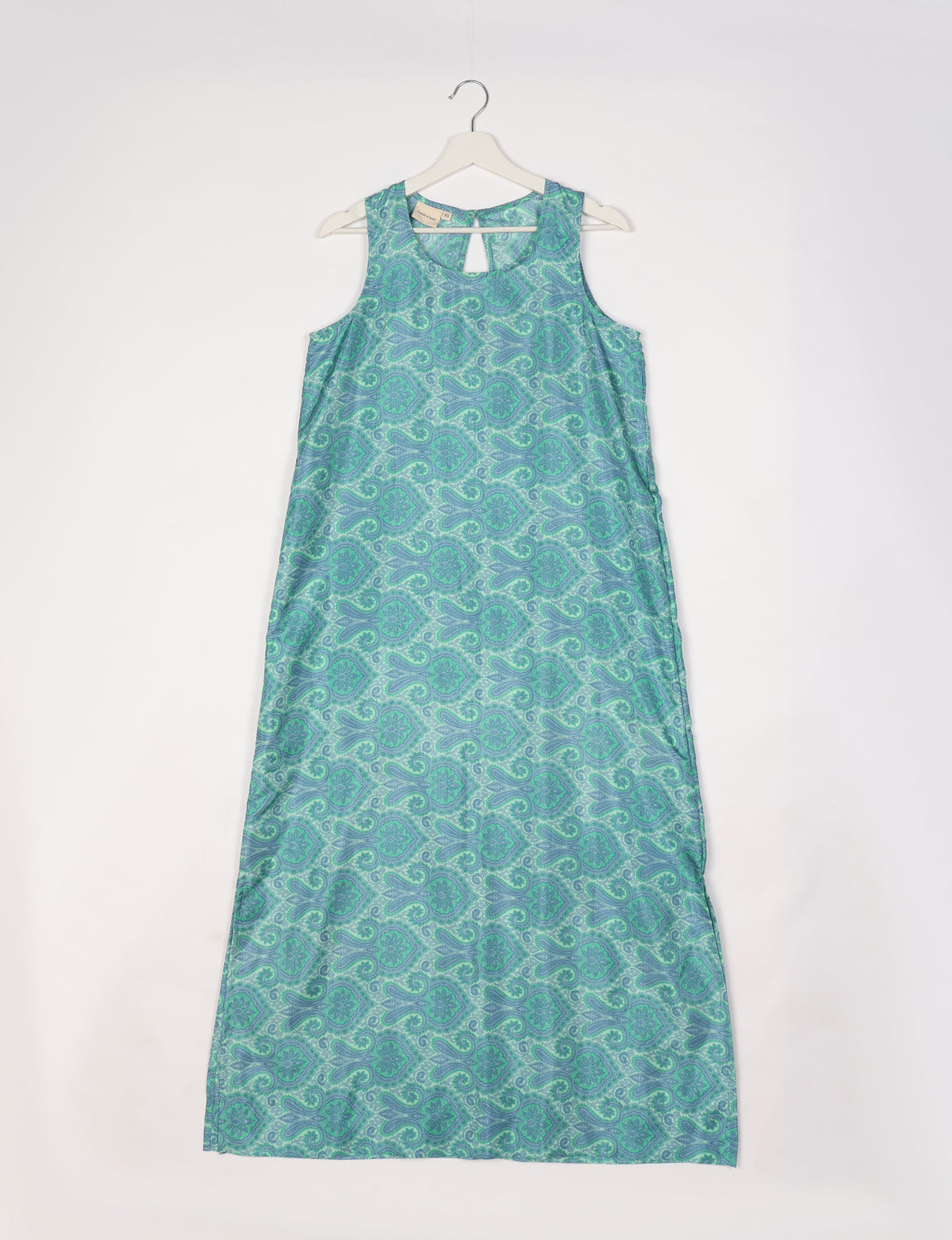 Blue sleeveless A-line maxi dress with green paisley pattern, keyhole neckline, hanging on white hanger, size XS tag visible