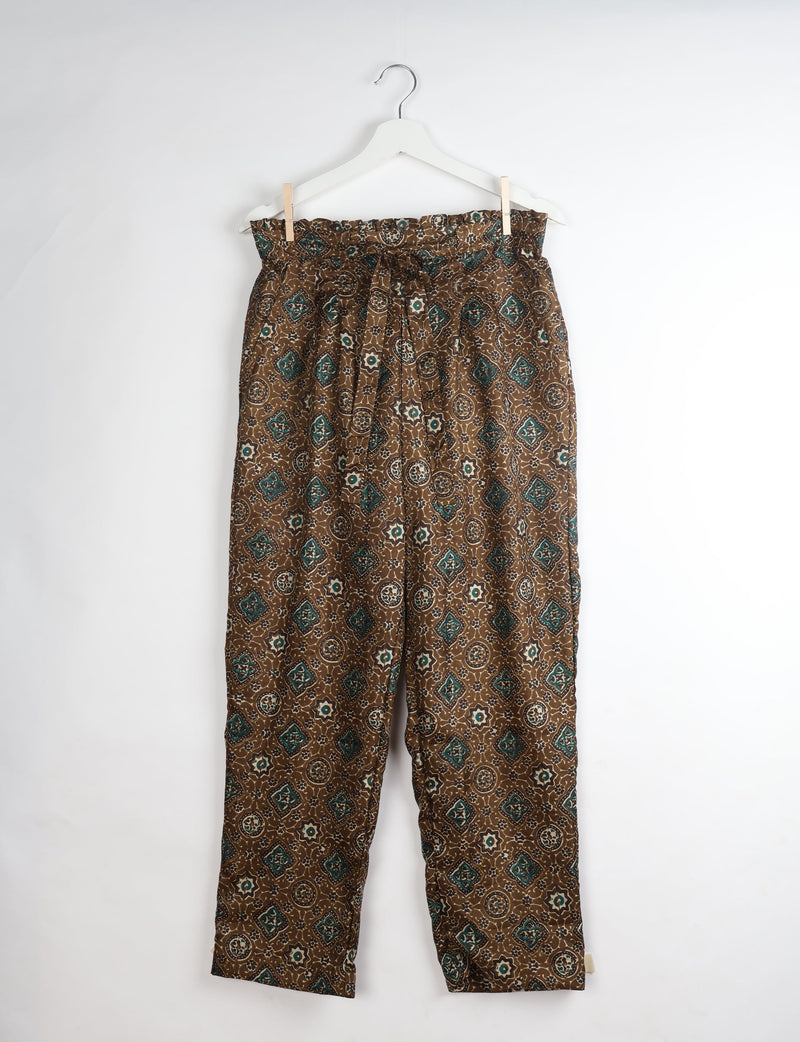Brown paperbag high-waisted pull-on pants with green and cream Indian ethnic print, hanging on white hanger