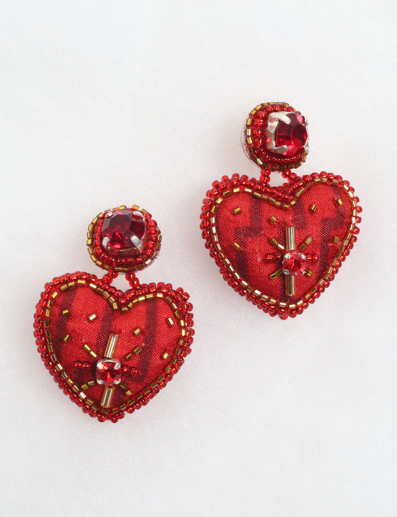 Red heart drop earrings with red and gold beads and red gemstone accents on a white background