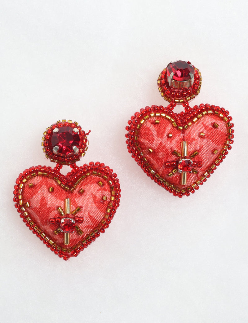 Red heart drop earrings with fabric centers, red and gold bead embellishments, and red gemstone studs, shown on white background