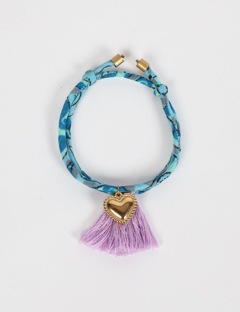 Blue patterned rope bracelet with gold heart charm and purple tassels, shown flat on white background