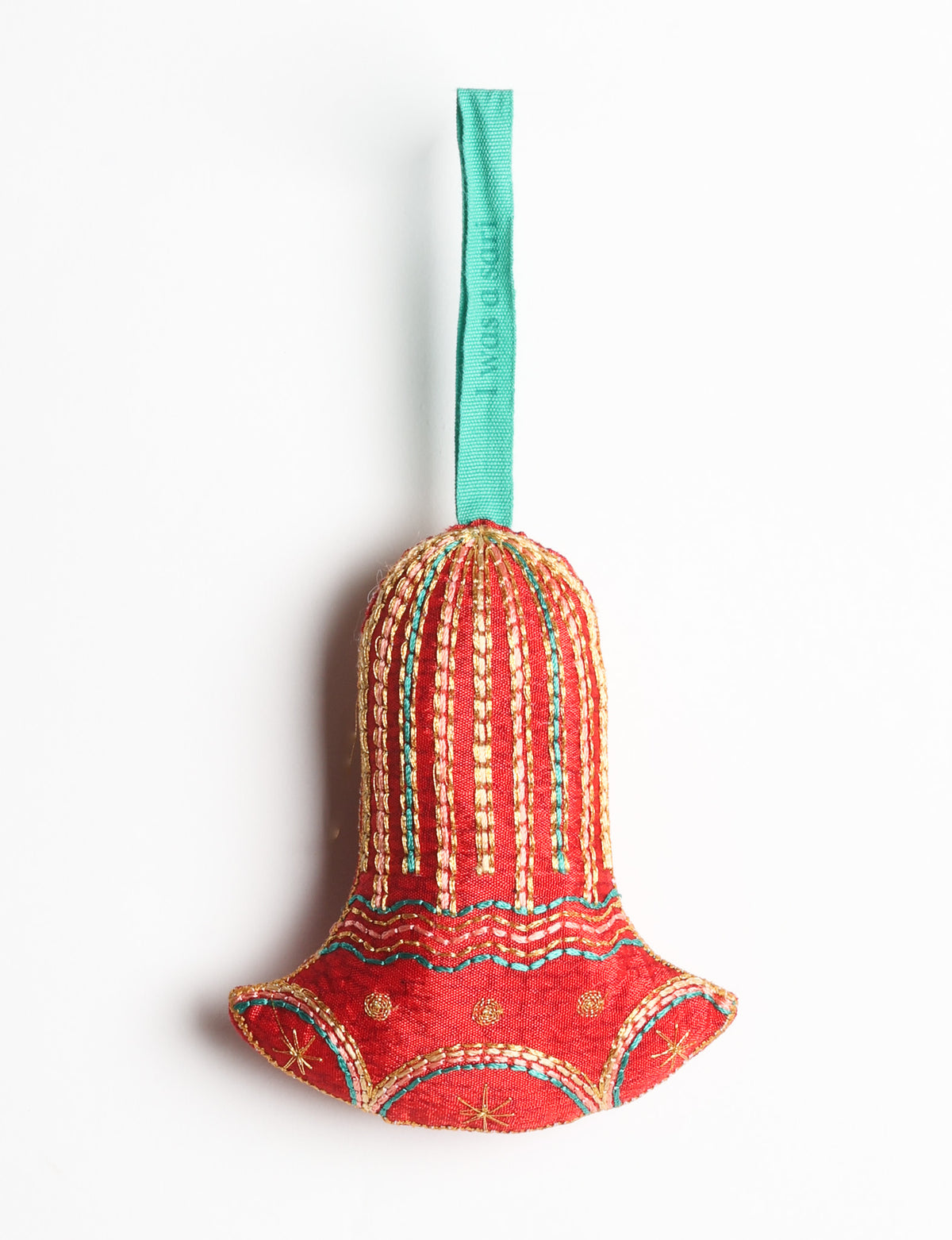 Red fabric bell ornament with gold and teal stitched details and a teal hanging loop with faint text visible