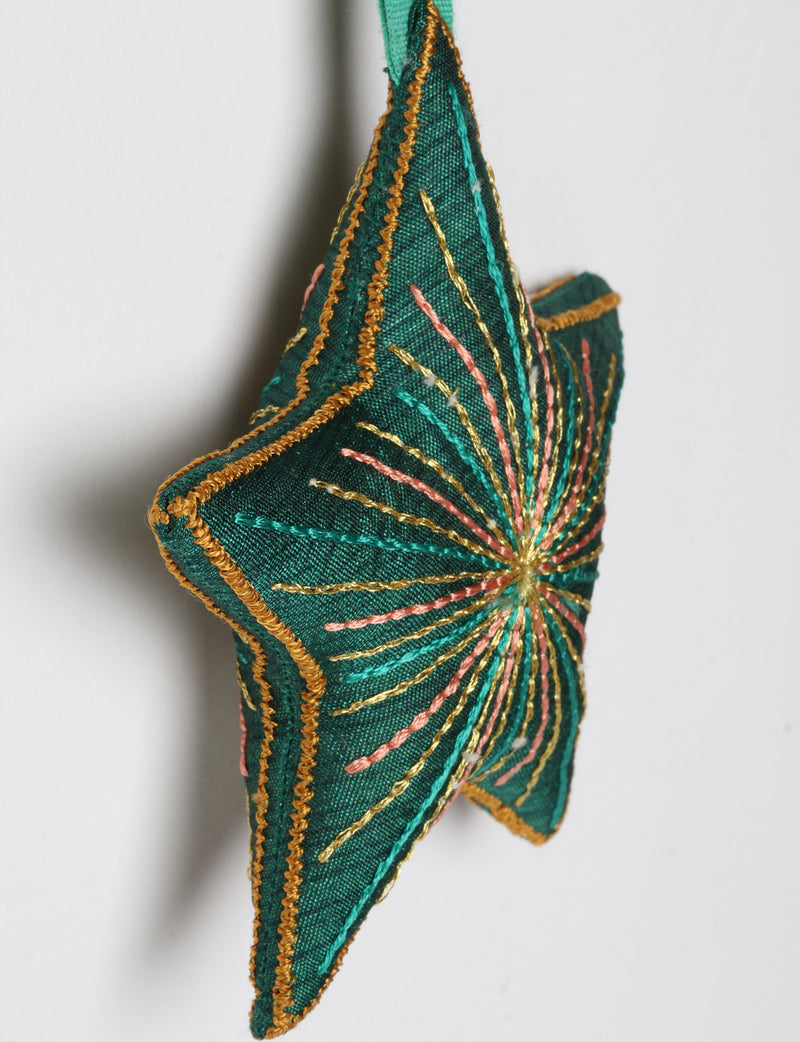 Timeless star ornament made from recycled sari fabric, featuring silk and metallic embroidery, crafted as part of green fashion, recycled clothing design, environmentally friendly clothing practices, and repurposed clothing traditions.