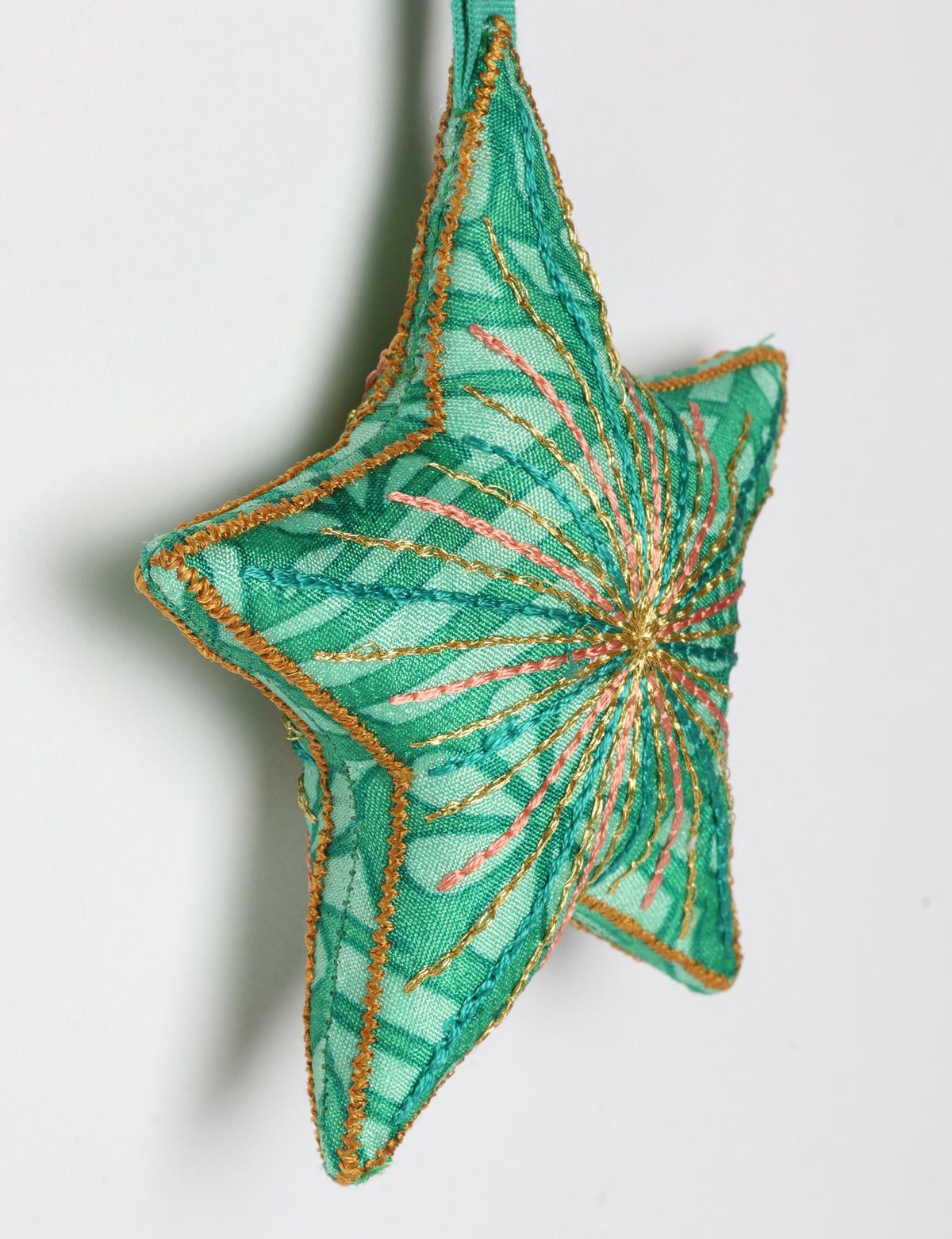 Timeless star ornament made from recycled sari fabric, featuring silk and metallic embroidery, crafted as part of green fashion, recycled clothing design, environmentally friendly clothing practices, and repurposed clothing traditions.