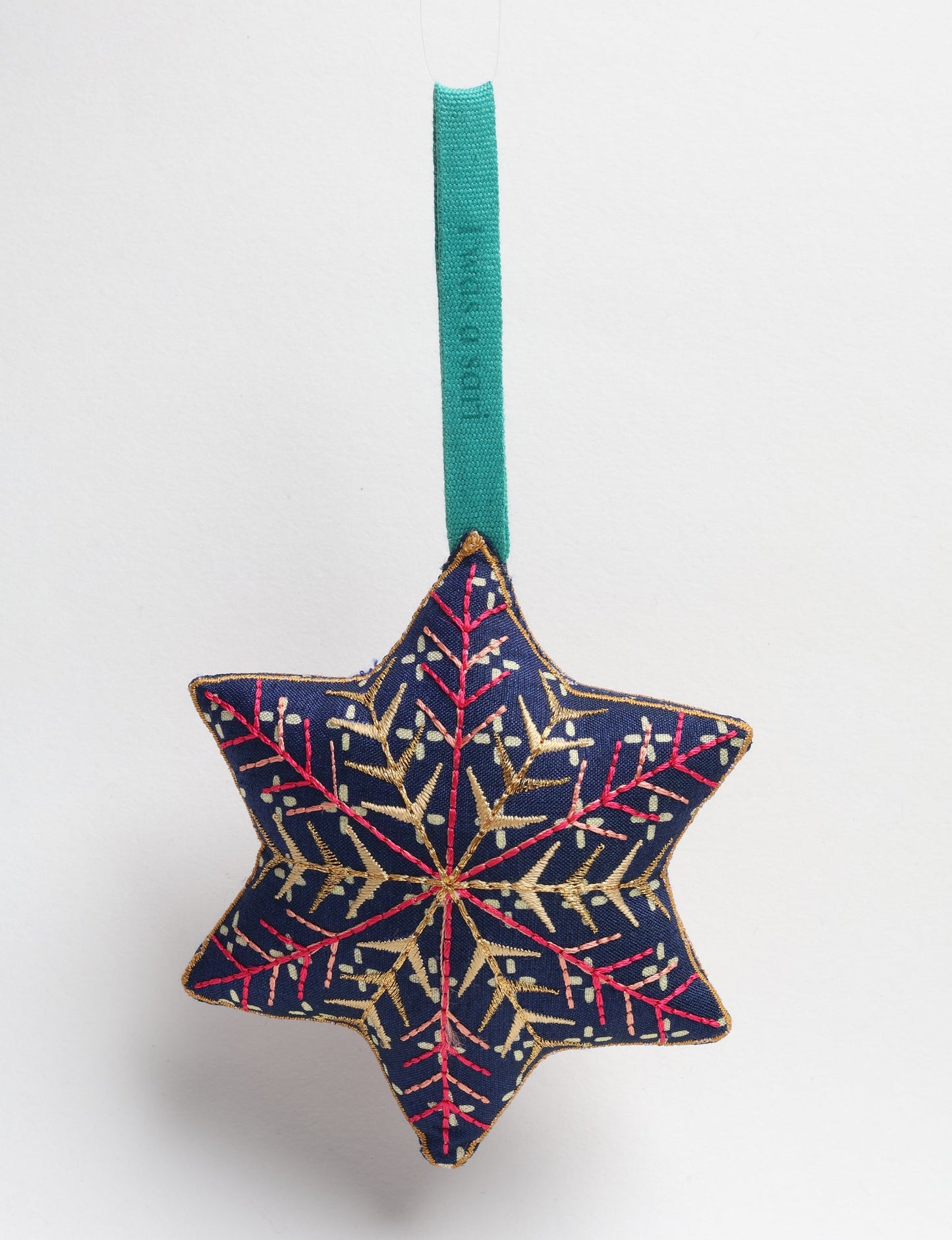 Timeless snowflake ornament made from preloved sari fabric with metallic embroidery, promoting green fashion, fair trade fashion, recycled material clothing, repurposed clothing, sustainable women's clothing, and circular fashion for a conscious lifestyle.
