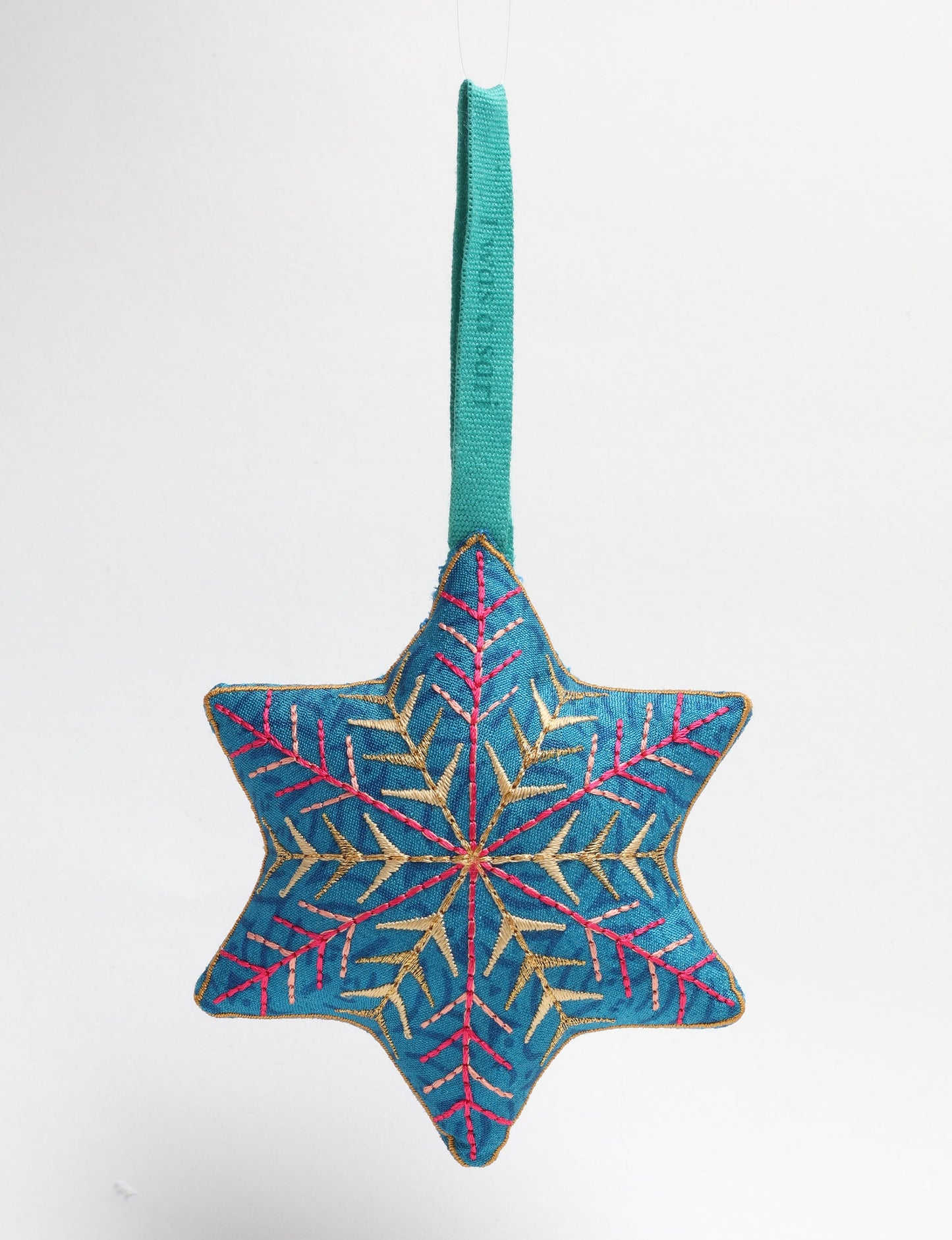 Timeless snowflake ornament made from preloved sari fabric with metallic embroidery, promoting green fashion, fair trade fashion, recycled material clothing, repurposed clothing, sustainable women's clothing, and circular fashion for a conscious lifestyle.