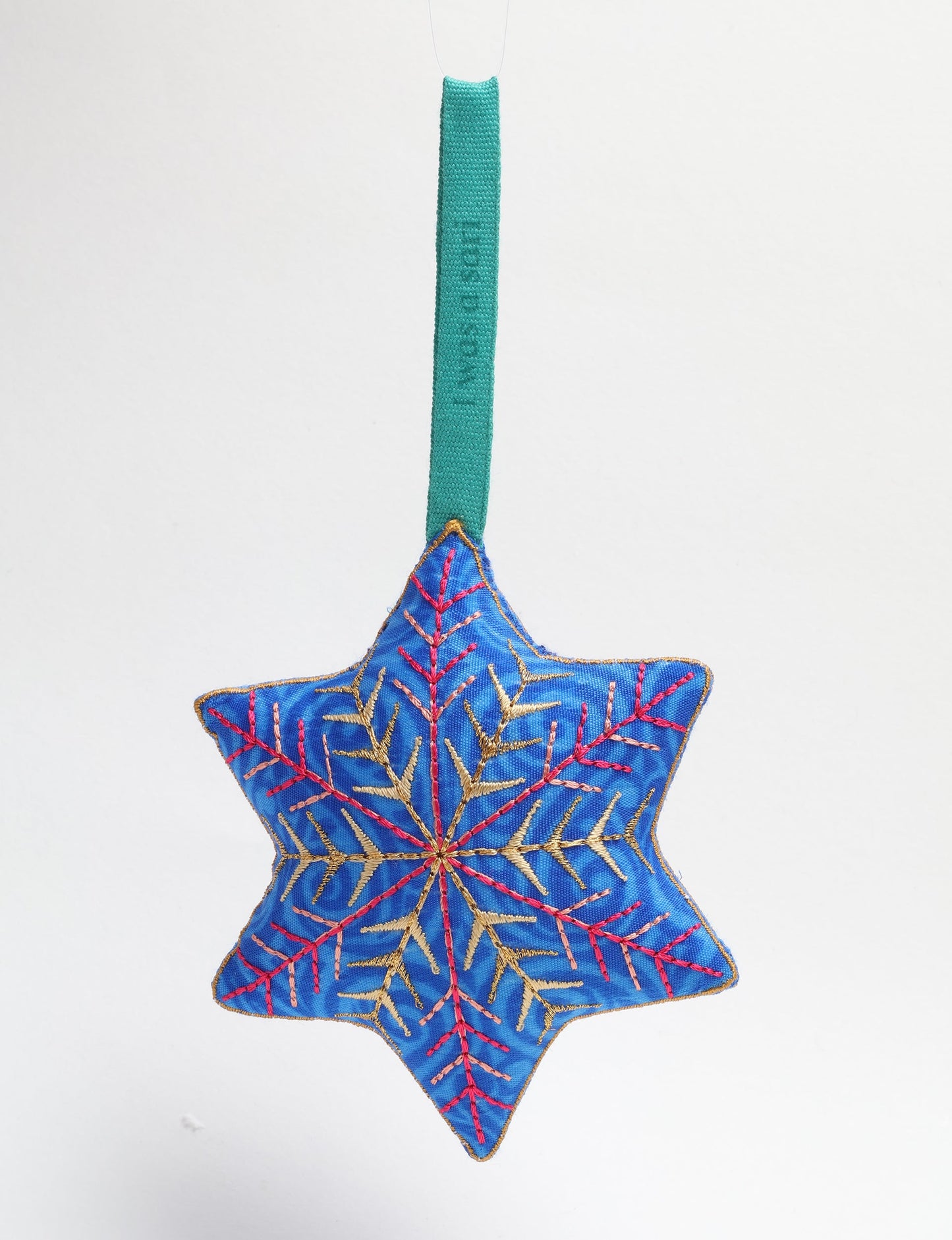 Timeless snowflake ornament made from preloved sari fabric with metallic embroidery, promoting green fashion, fair trade fashion, recycled material clothing, repurposed clothing, sustainable women's clothing, and circular fashion for a conscious lifestyle.