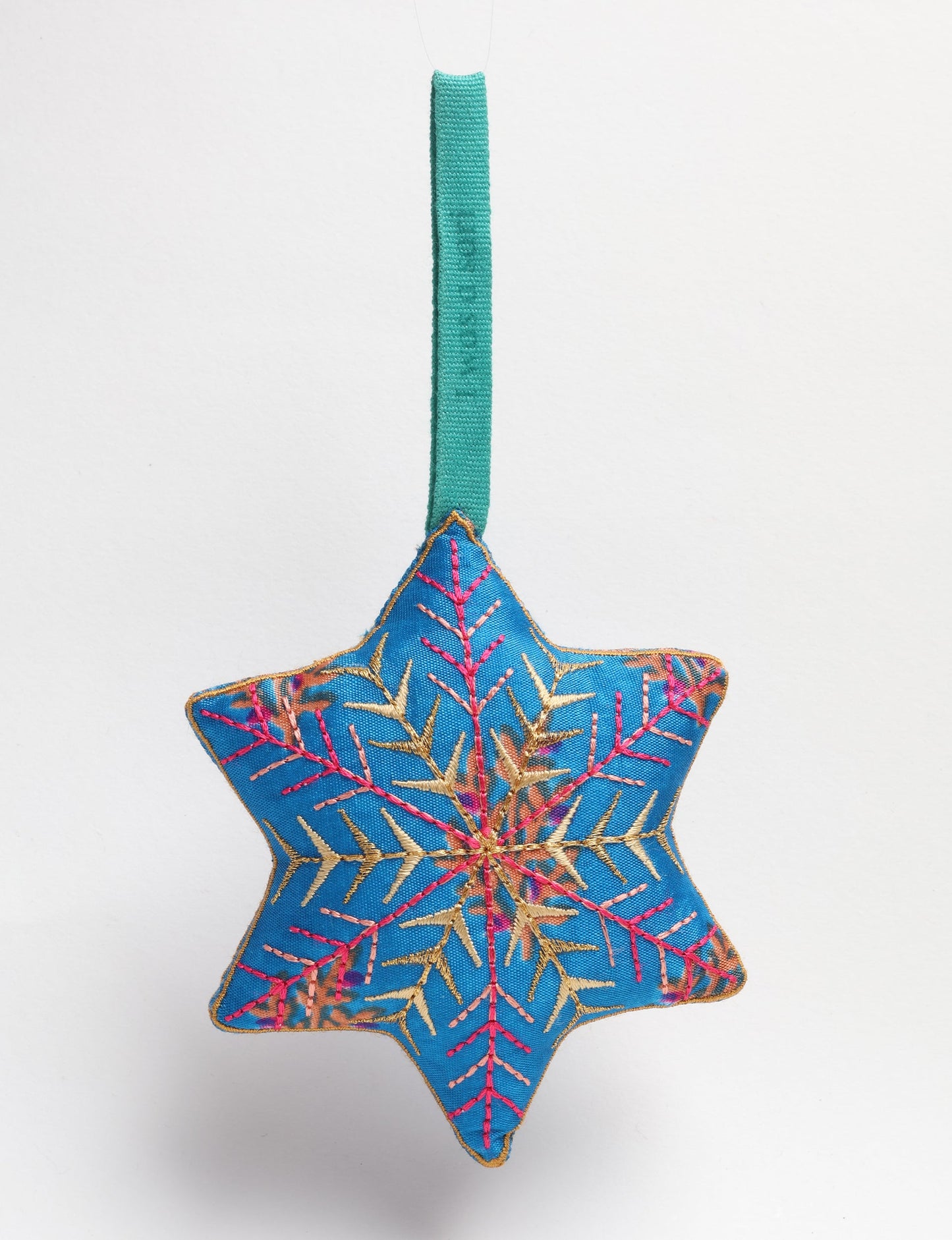 Timeless snowflake ornament made from preloved sari fabric with metallic embroidery, promoting green fashion, fair trade fashion, recycled material clothing, repurposed clothing, sustainable women's clothing, and circular fashion for a conscious lifestyle.