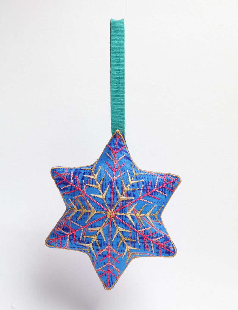 Blue fabric star-shaped ornament with gold and pink embroidered snowflake design and green hanging loop