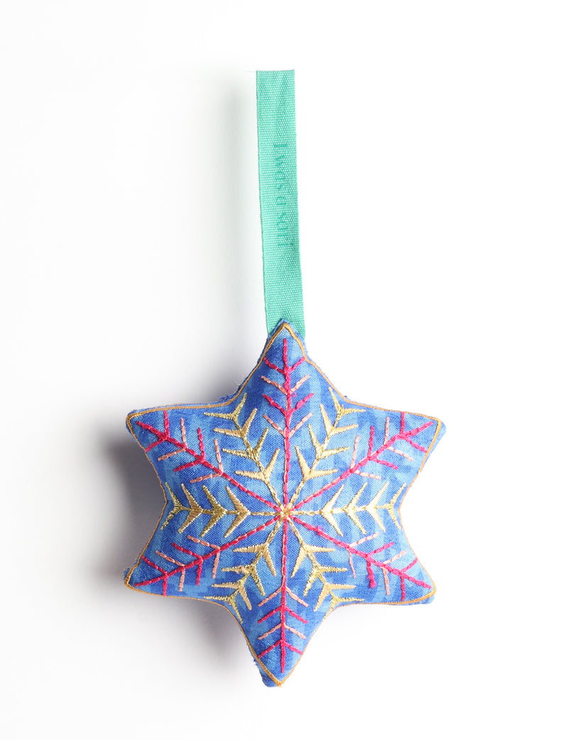 Blue fabric star-shaped ornament with gold and pink embroidered snowflake design and green hanging loop