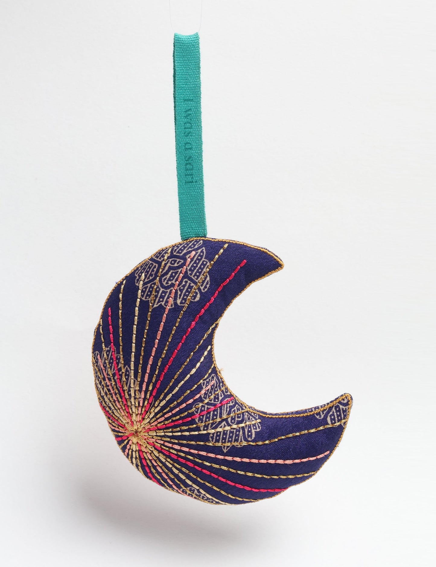 Timeless crescent moon ornament made from recycled materials and textile waste, featuring intricate embroidery. A zero waste and carbon offset accessory that supports circular fashion, fair trade fashion, and environmentally friendly clothing choices.