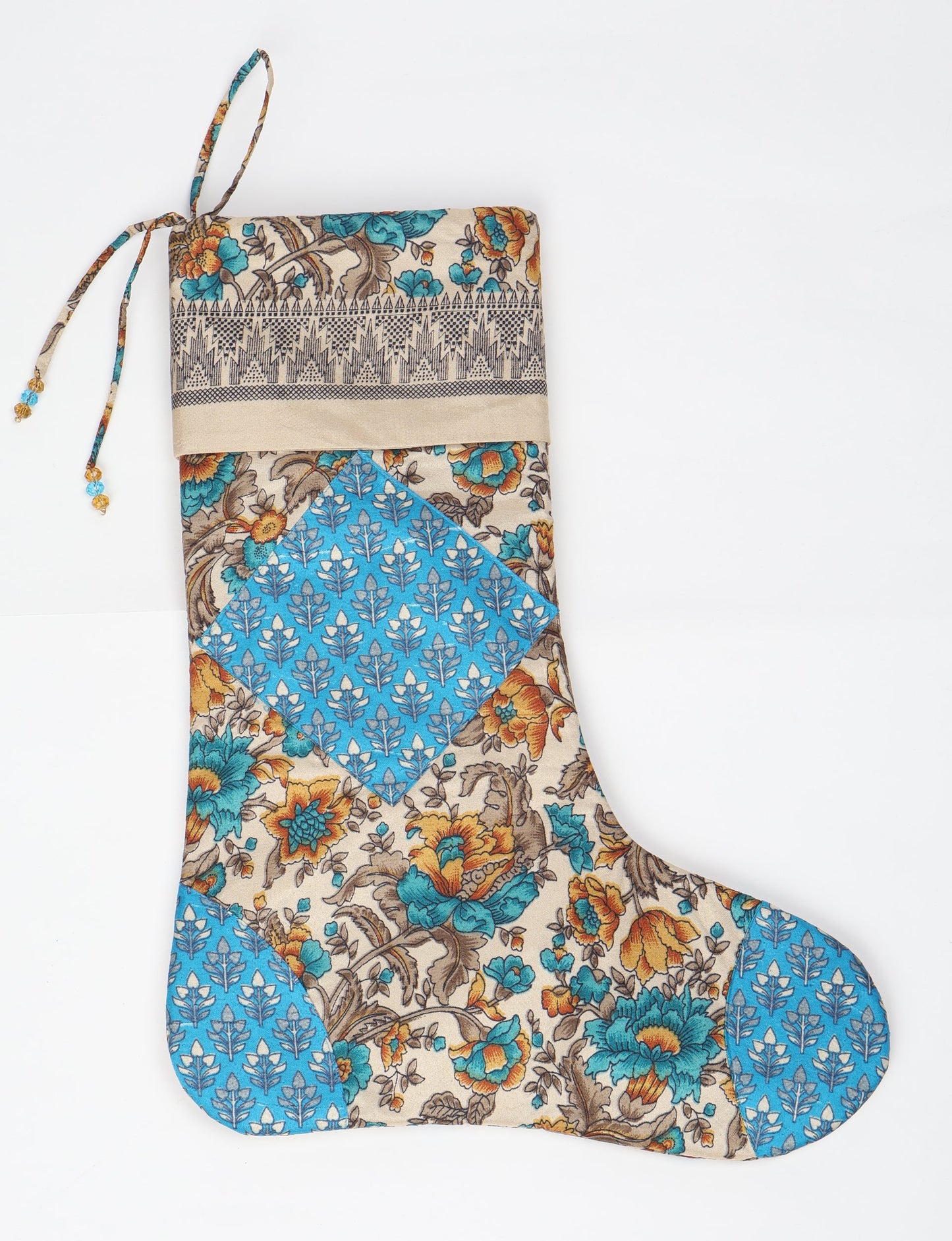 Timeless Christmas stocking made from recycled sari fabric, featuring colorful patchwork, tassel details, and crafted with care in line with circular fashion, upcycling fashion, carbon neutral clothing, and environmentally friendly clothing ideals — a beautiful piece of repurposed clothing and eco clothing for sustainable women’s fashion.