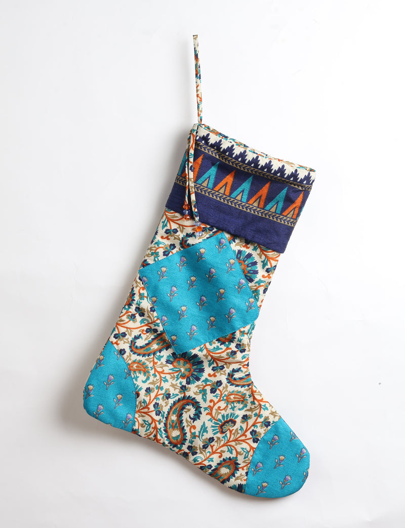 Timeless Christmas stocking made from recycled sari fabric, featuring colorful patchwork, tassel details, and crafted with care in line with circular fashion, upcycling fashion, carbon neutral clothing, and environmentally friendly clothing ideals — a beautiful piece of repurposed clothing and eco clothing for sustainable women’s fashion.
