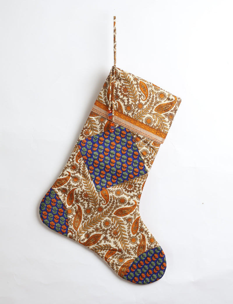 Timeless Christmas stocking made from recycled sari fabric, featuring colorful patchwork, tassel details, and crafted with care in line with circular fashion, upcycling fashion, carbon neutral clothing, and environmentally friendly clothing ideals — a beautiful piece of repurposed clothing and eco clothing for sustainable women’s fashion.