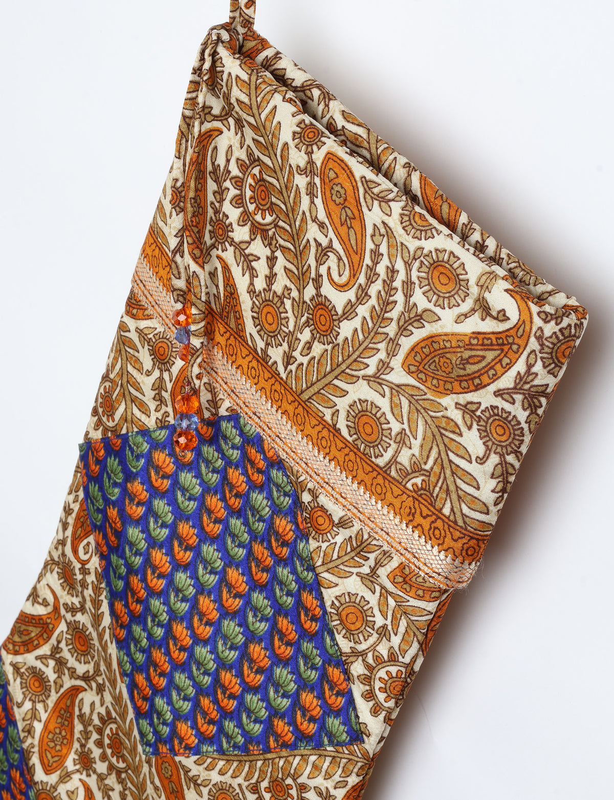 Timeless Christmas stocking made from recycled sari fabric, featuring colorful patchwork, tassel details, and crafted with care in line with circular fashion, upcycling fashion, carbon neutral clothing, and environmentally friendly clothing ideals — a beautiful piece of repurposed clothing and eco clothing for sustainable women’s fashion.