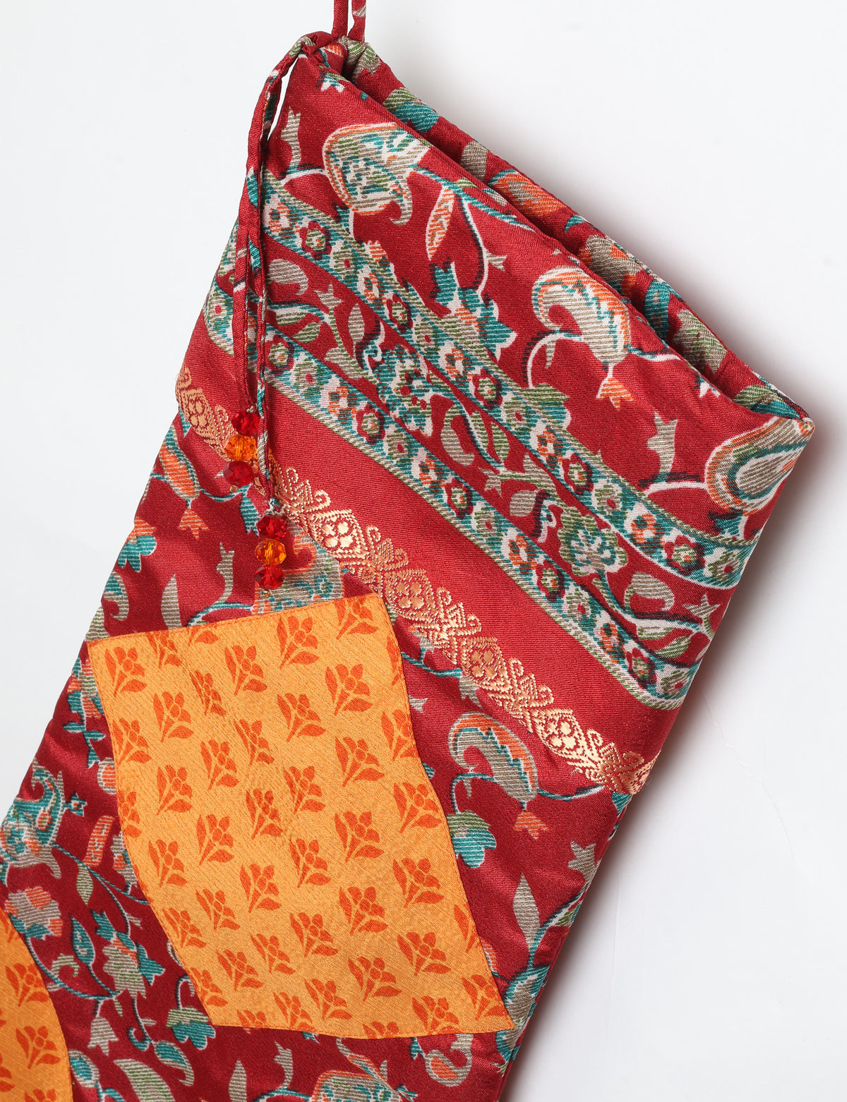 Timeless Christmas stocking made from recycled sari fabric, featuring colorful patchwork, tassel details, and crafted with care in line with circular fashion, upcycling fashion, carbon neutral clothing, and environmentally friendly clothing ideals — a beautiful piece of repurposed clothing and eco clothing for sustainable women’s fashion.