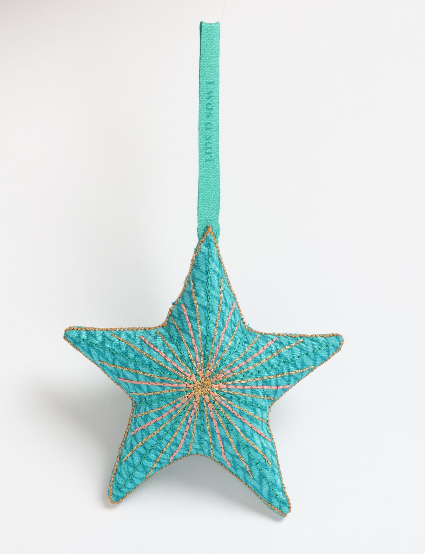 Timeless star ornament made from recycled sari fabric, featuring silk and metallic embroidery, crafted as part of green fashion, recycled clothing design, environmentally friendly clothing practices, and repurposed clothing traditions.