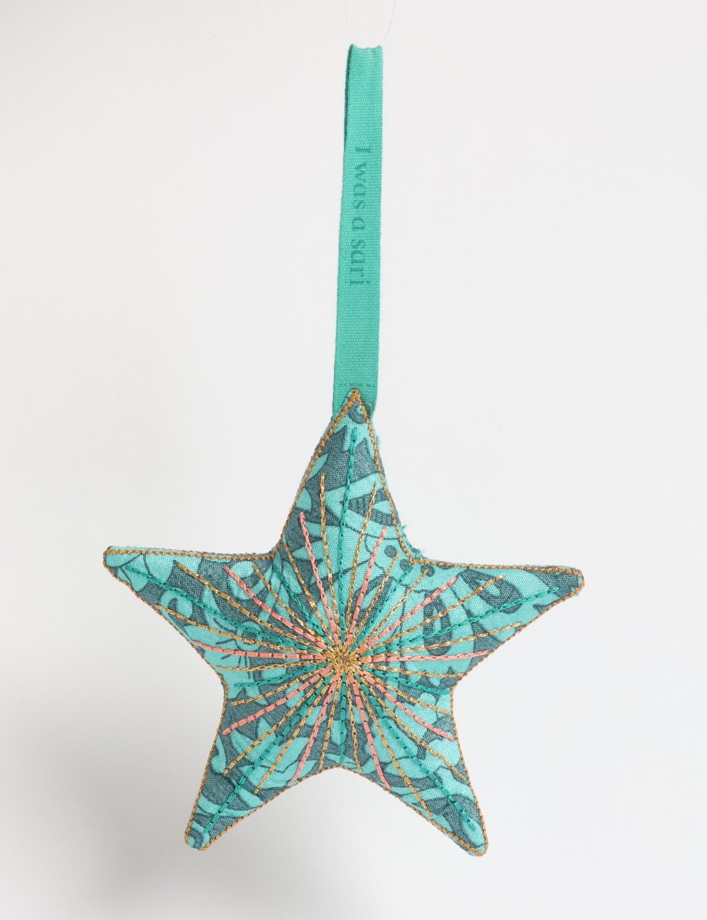 Timeless star ornament made from recycled sari fabric, featuring silk and metallic embroidery, crafted as part of green fashion, recycled clothing design, environmentally friendly clothing practices, and repurposed clothing traditions.