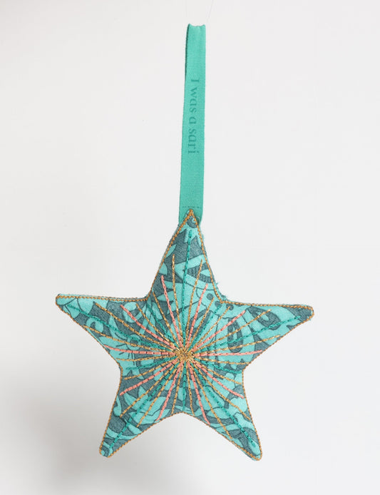 Timeless star ornament made from recycled sari fabric, featuring silk and metallic embroidery, crafted as part of green fashion, recycled clothing design, environmentally friendly clothing practices, and repurposed clothing traditions.