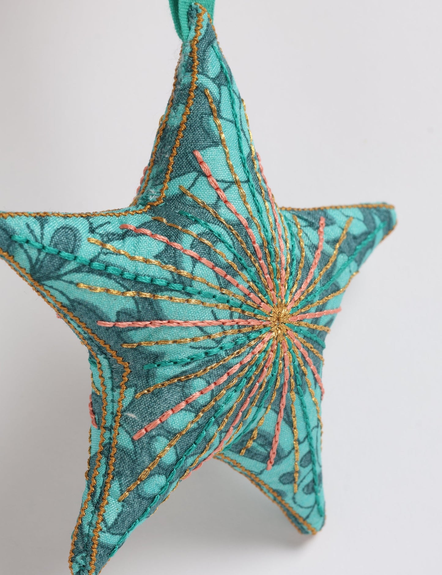Timeless star ornament made from recycled sari fabric, featuring silk and metallic embroidery, crafted as part of green fashion, recycled clothing design, environmentally friendly clothing practices, and repurposed clothing traditions.