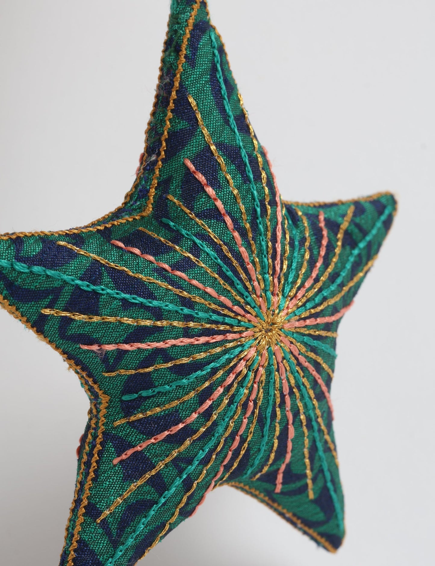 Timeless star ornament made from recycled sari fabric, featuring silk and metallic embroidery, crafted as part of green fashion, recycled clothing design, environmentally friendly clothing practices, and repurposed clothing traditions.