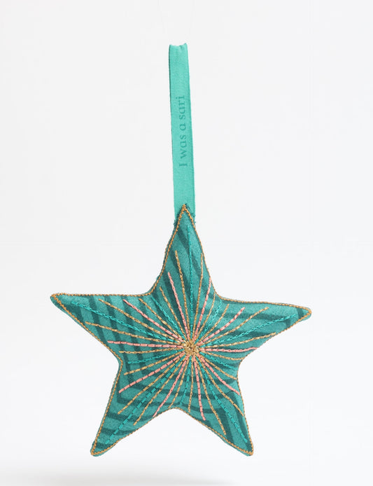 Timeless star ornament made from recycled sari fabric, featuring silk and metallic embroidery, crafted as part of green fashion, recycled clothing design, environmentally friendly clothing practices, and repurposed clothing traditions.