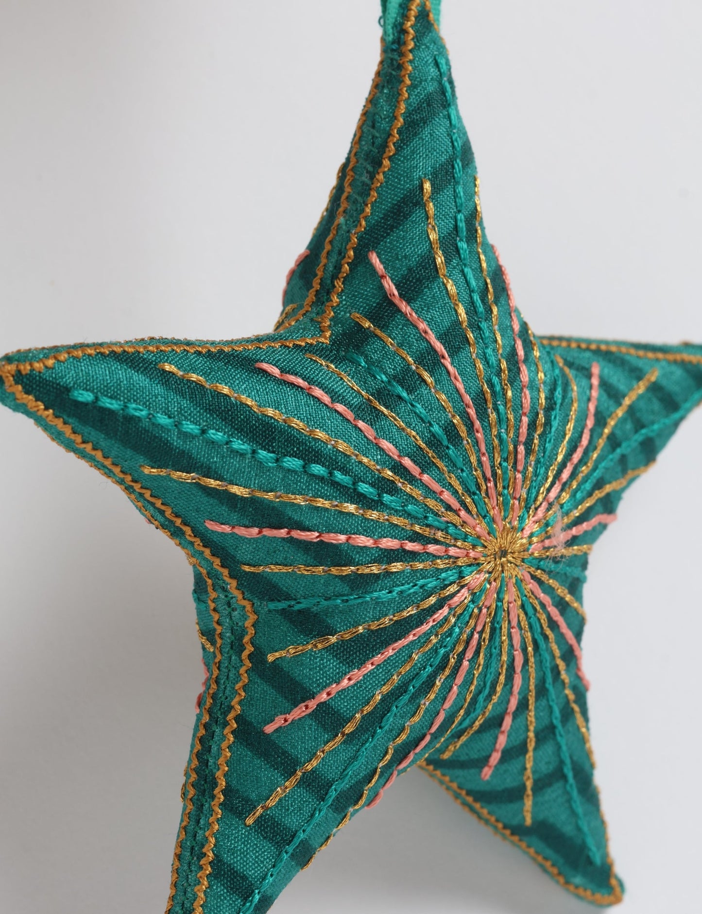 Timeless star ornament made from recycled sari fabric, featuring silk and metallic embroidery, crafted as part of green fashion, recycled clothing design, environmentally friendly clothing practices, and repurposed clothing traditions.