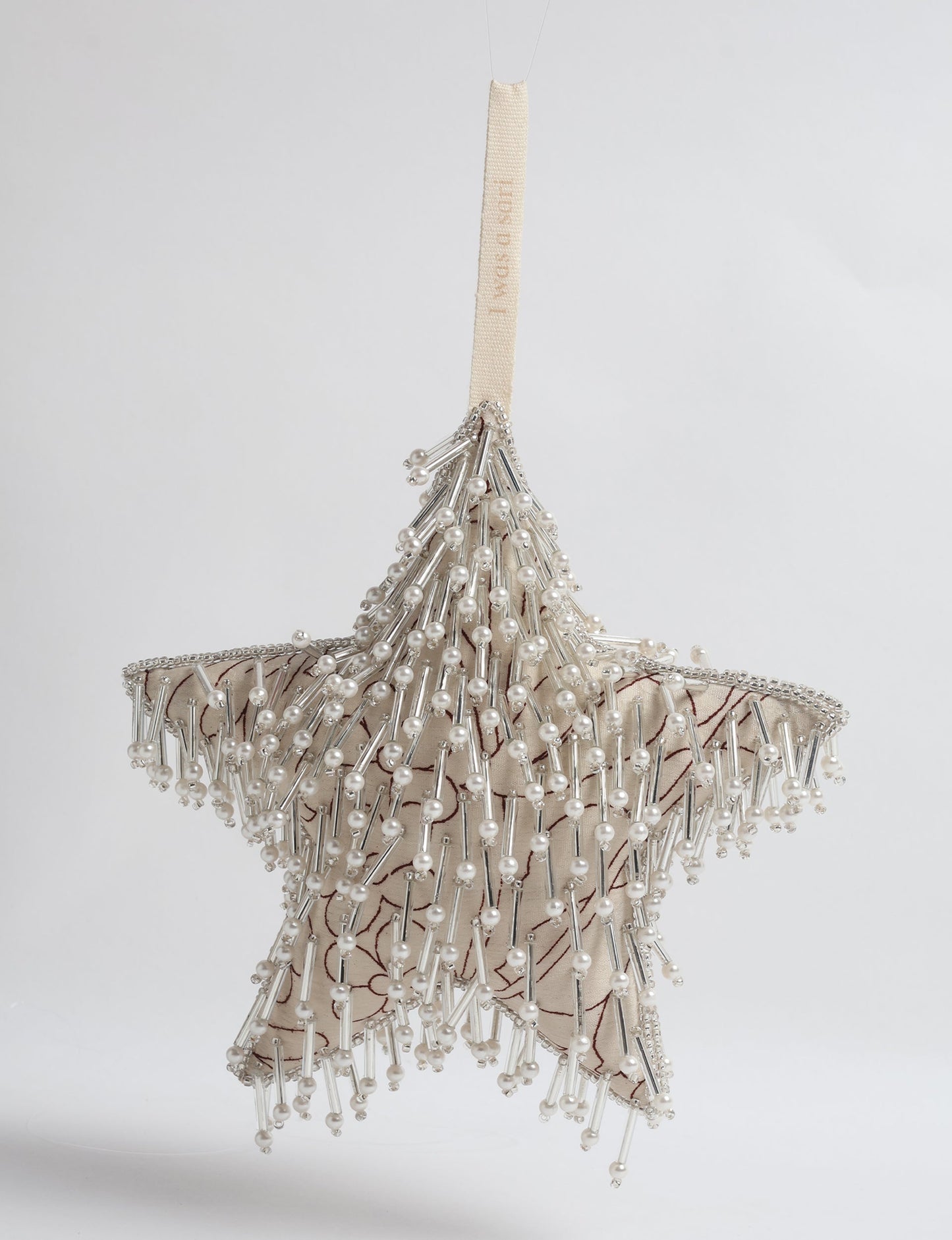 Upcycled silver star Christmas ornament made from recycled sari fabric, hand embroidered with sequins, pearls, and glass beads — a fair trade, slow fashion, and zero waste clothing accessory.