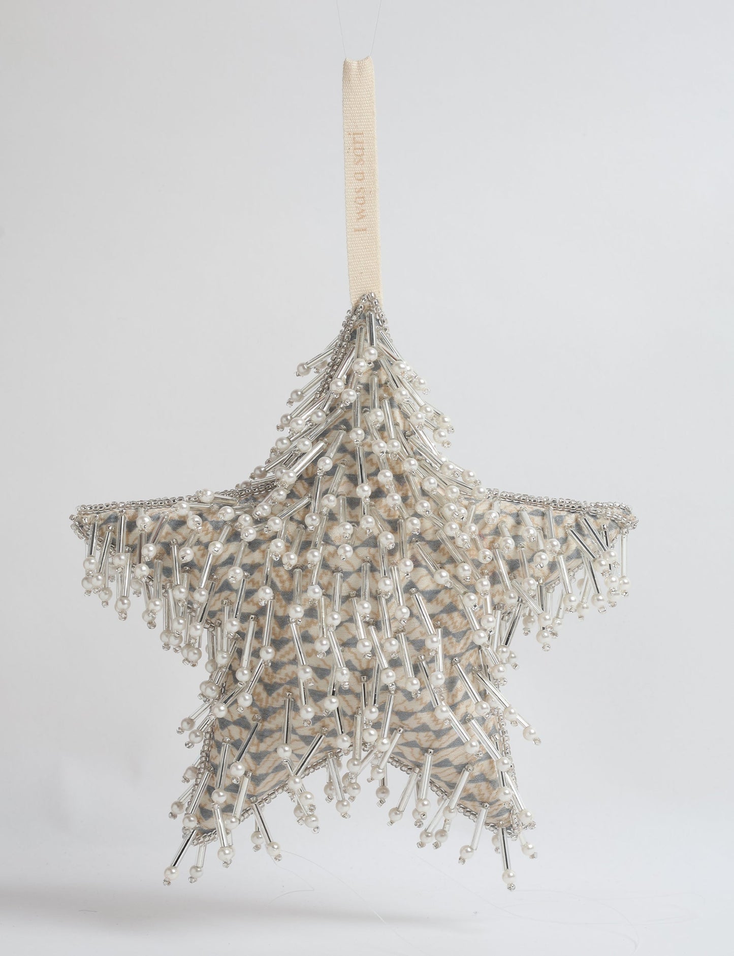 Upcycled silver star Christmas ornament made from recycled sari fabric, hand embroidered with sequins, pearls, and glass beads — a fair trade, slow fashion, and zero waste clothing accessory.