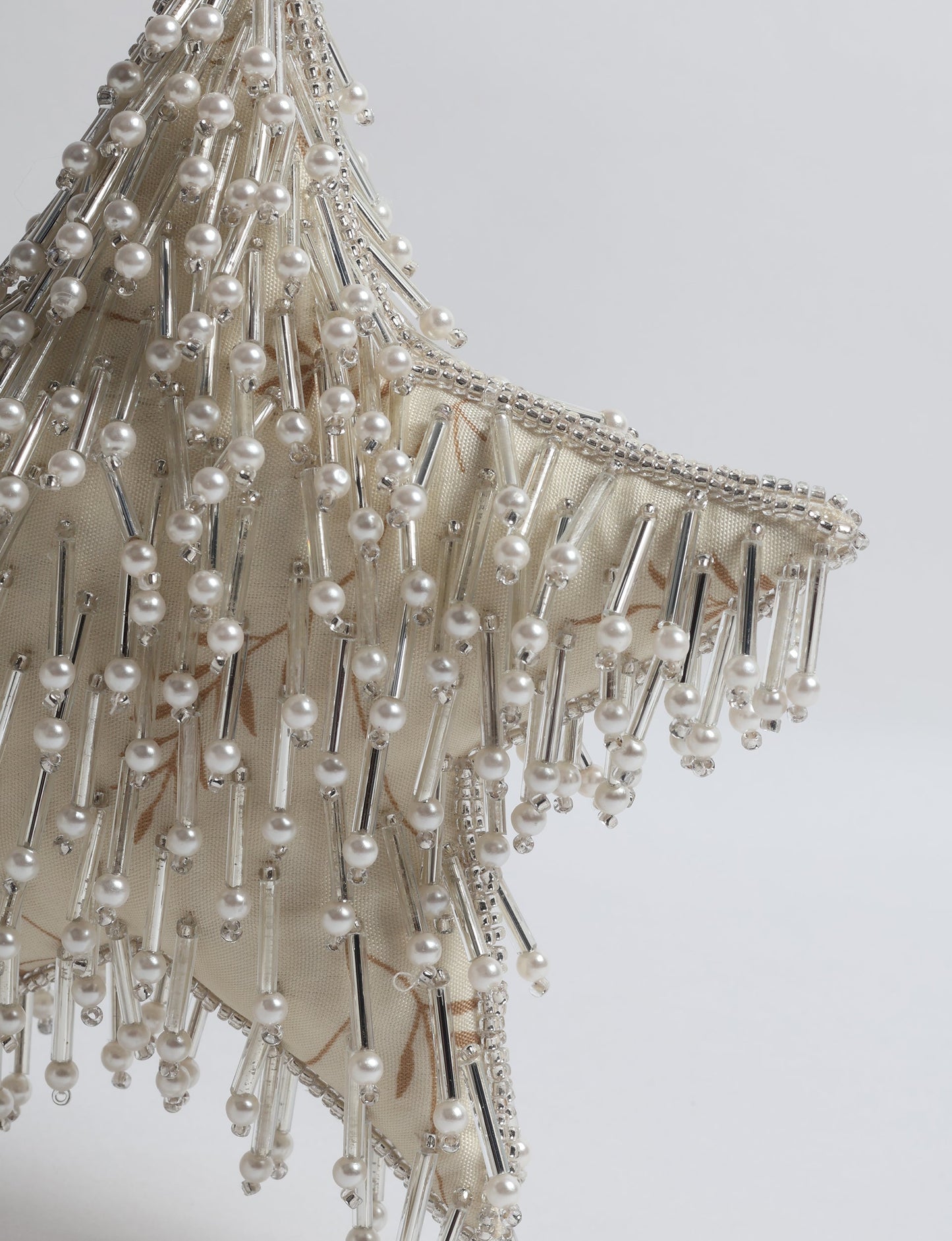 Upcycled silver star Christmas ornament made from recycled sari fabric, hand embroidered with sequins, pearls, and glass beads — a fair trade, slow fashion, and zero waste clothing accessory.