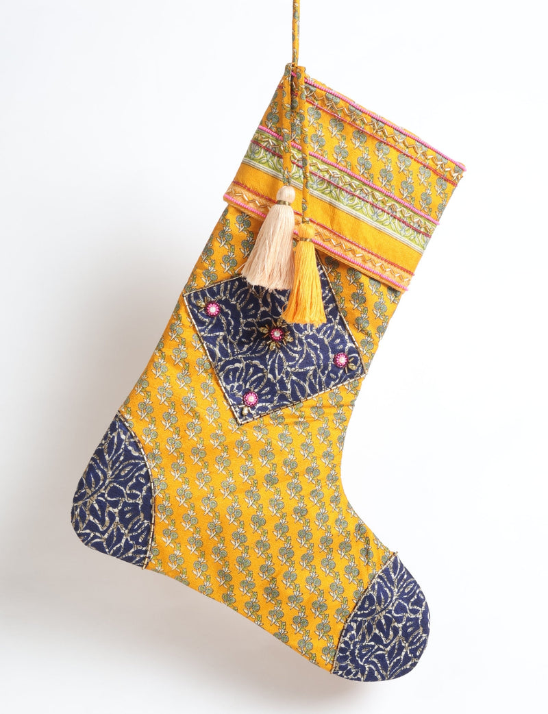 Yellow Christmas stocking with green floral micro design, navy blue patch with pink bead accents, and two hanging tassels