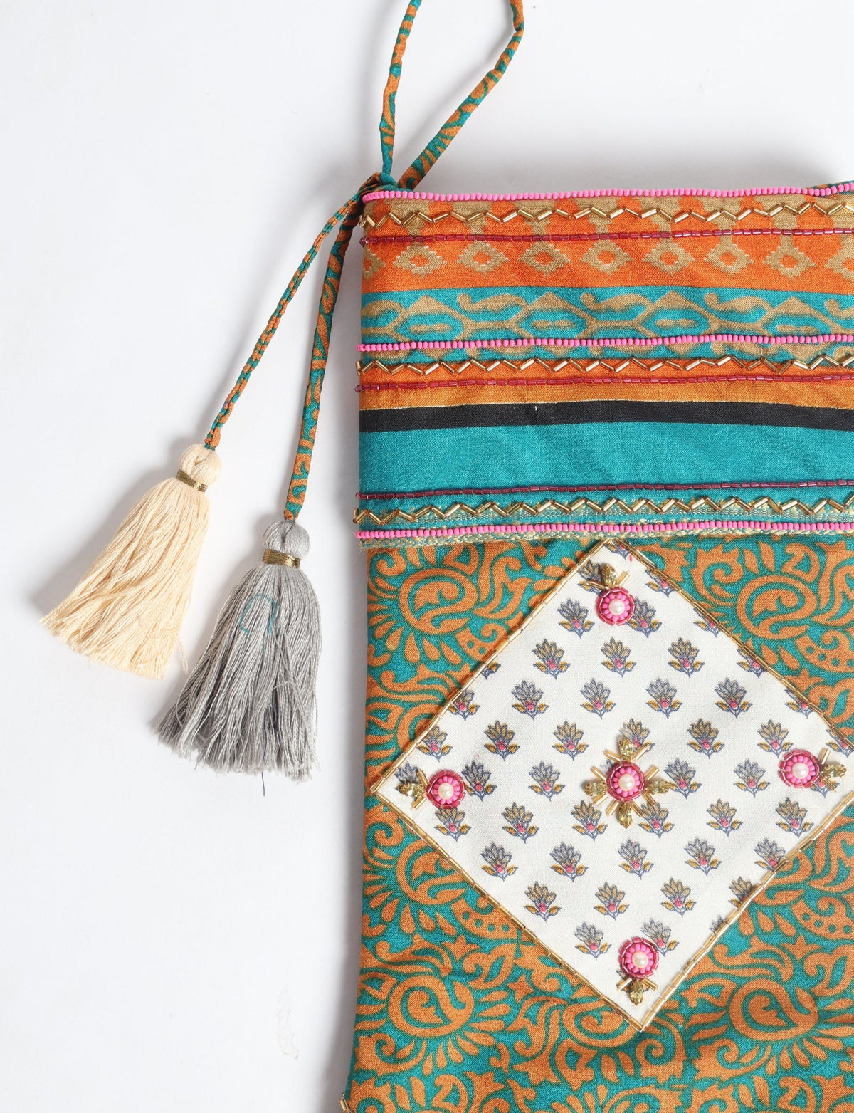 Christmas stocking in blue and orange paisley pattern with decorative tassels and beaded embellishments, flat lay view