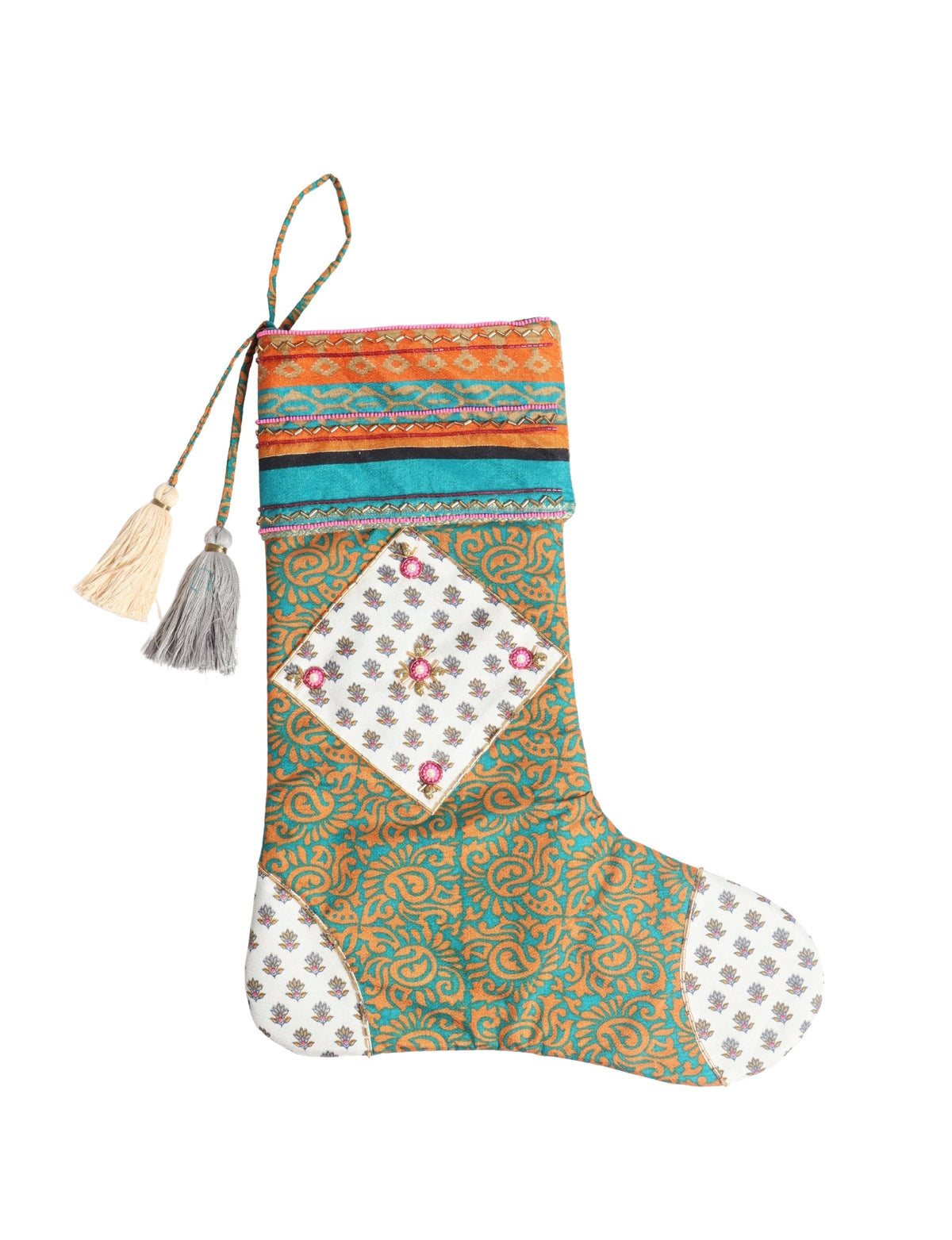 Christmas stocking with blue and orange paisley pattern, white floral patches, and two hanging tassels, flat lay view