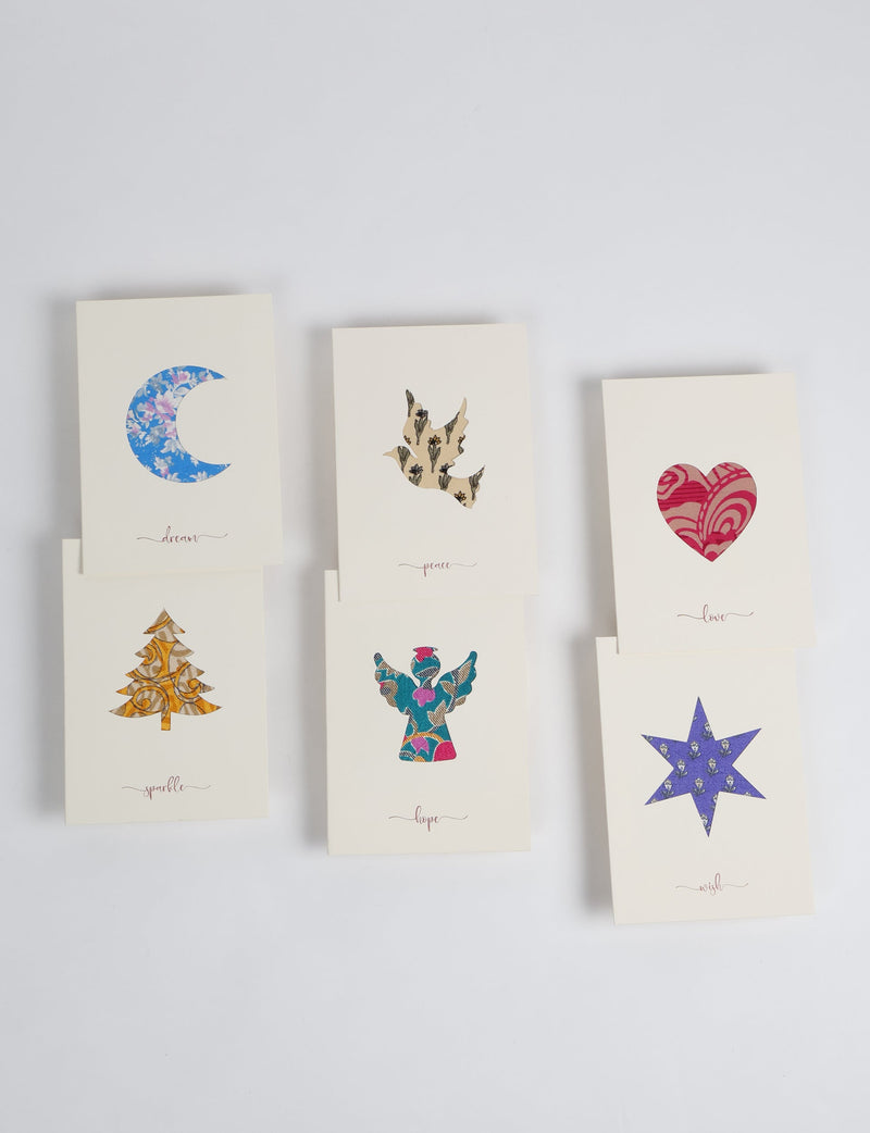 Folded cream celebration card set with six pieces featuring cutout shapes filled with colorful floral and patterned designs