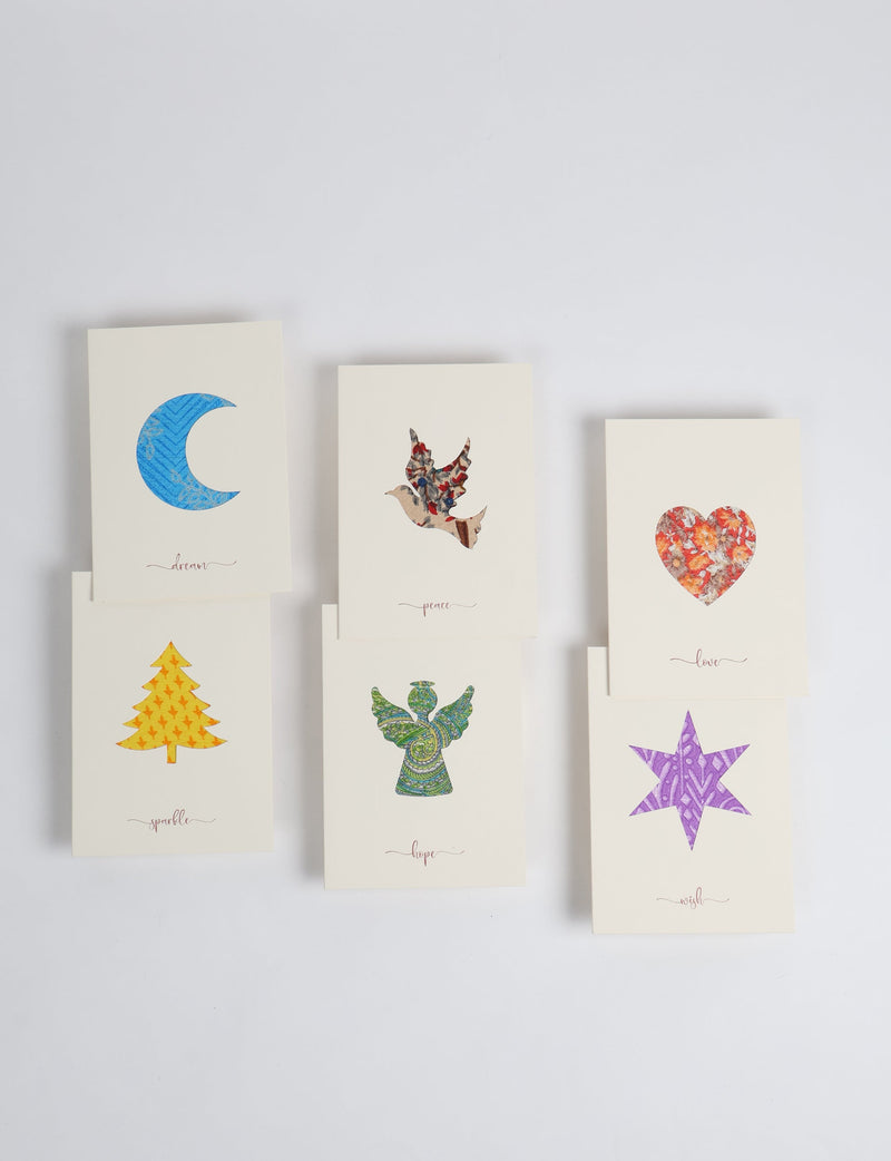 Set of six folded celebration cards with cutout shapes of a blue moon, multicolor dove, red heart, yellow tree, green angel