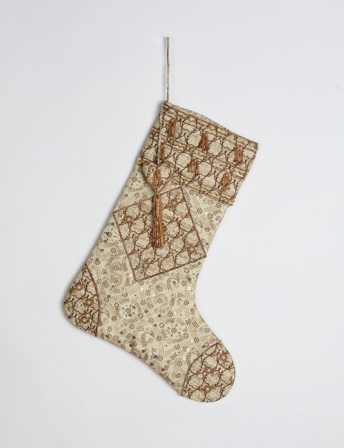 Ivory and cream upcycled sari Christmas stocking with gold hand embroidery, patchwork detailing, and a beaded heart charm tassel — crafted from recycled materials and inspired by circular, fair trade, and eco clothing fashion.