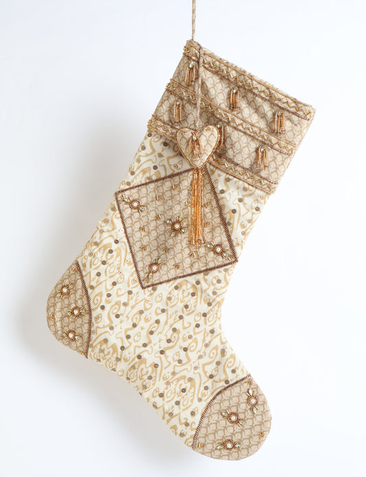 Ivory and cream upcycled sari Christmas stocking with gold hand embroidery, patchwork detailing, and a beaded heart charm tassel — crafted from recycled materials and inspired by circular, fair trade, and eco clothing fashion.