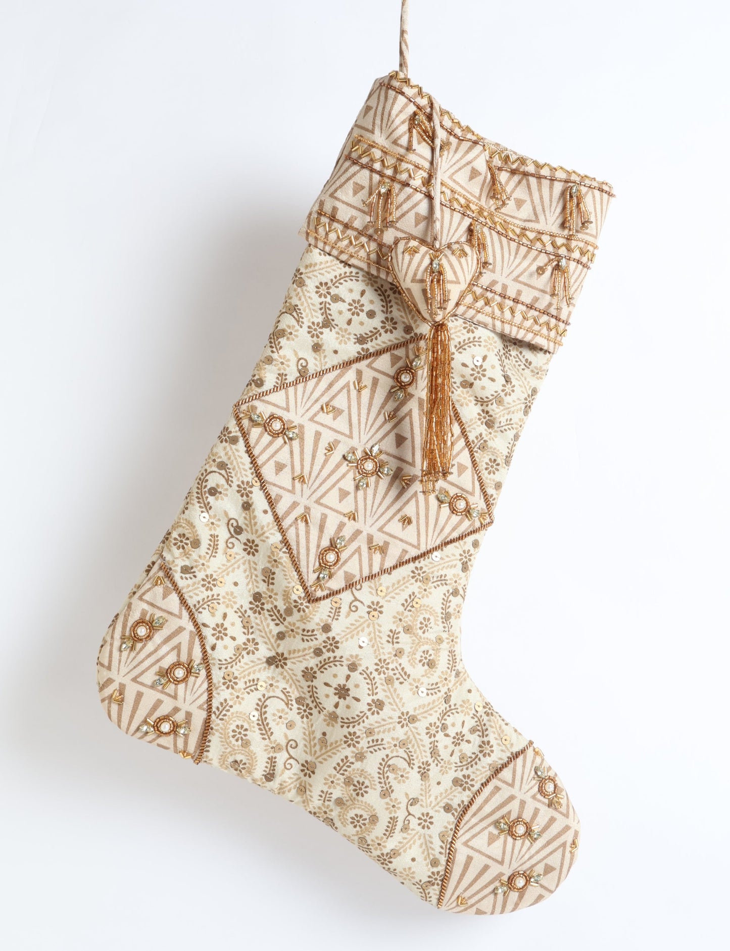 Ivory and cream upcycled sari Christmas stocking with gold hand embroidery, patchwork detailing, and a beaded heart charm tassel — crafted from recycled materials and inspired by circular, fair trade, and eco clothing fashion.