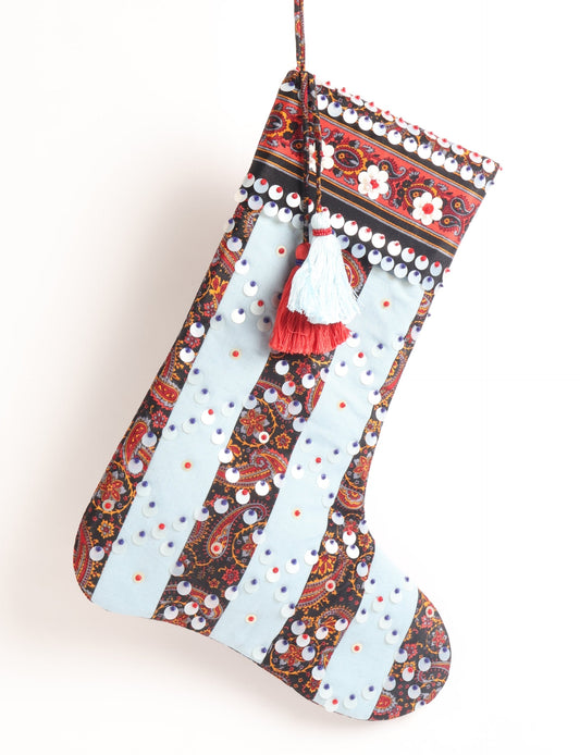 Upcycled sari Christmas stocking with striped cotton accents and hand-embroidered embellishments, reflecting green fashion, zero-waste clothing, recycled fashion, repurposed clothing, carbon-neutral fashion, natural clothing, conscious clothing, and sustainable women’s clothing.