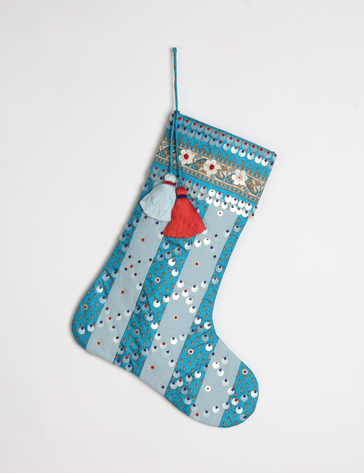 Upcycled sari Christmas stocking with striped cotton accents and hand-embroidered embellishments, reflecting green fashion, zero-waste clothing, recycled fashion, repurposed clothing, carbon-neutral fashion, natural clothing, conscious clothing, and sustainable women’s clothing.