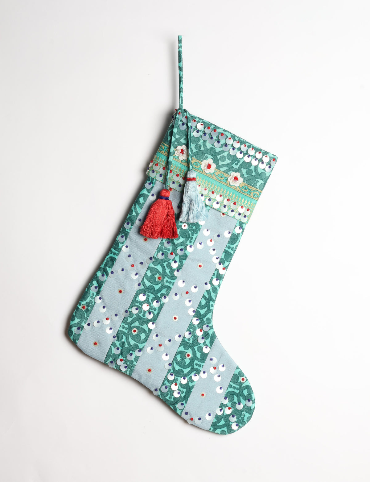 Upcycled sari Christmas stocking with striped cotton accents and hand-embroidered embellishments, reflecting green fashion, zero-waste clothing, recycled fashion, repurposed clothing, carbon-neutral fashion, natural clothing, conscious clothing, and sustainable women’s clothing.