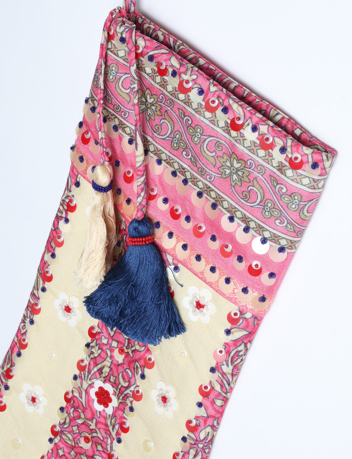 Blue and cream flower-patterned Christmas stocking with red, white, and purple sequins and two tassels hanging from the top loop