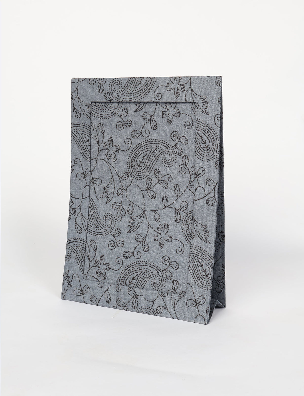 Gray fabric photo frame with black paisley and floral pattern, standing upright on a white background