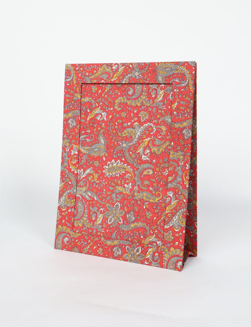 Brown tropical patterned photo frame with paisley and floral design, standing upright on a white background