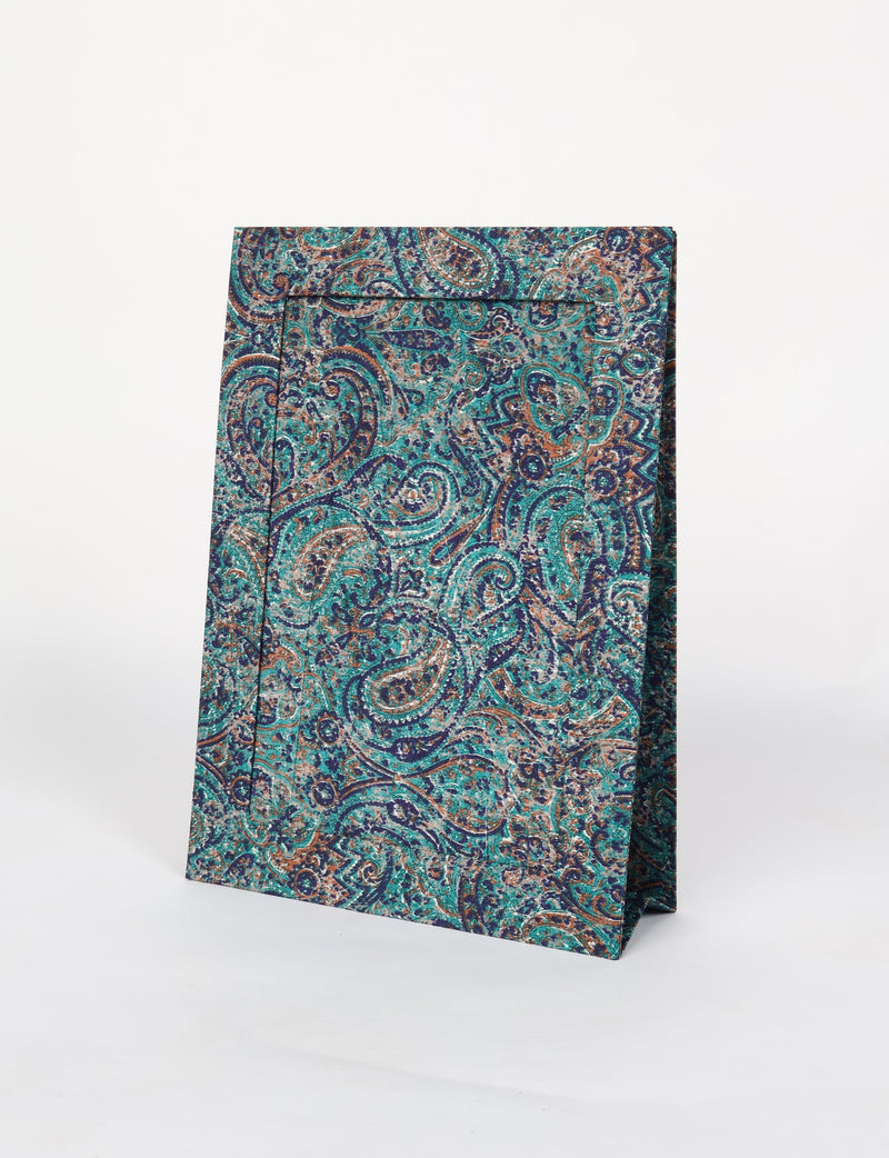 Standing gift bag with teal, brown, and navy paisley pattern on textured paper material against white background